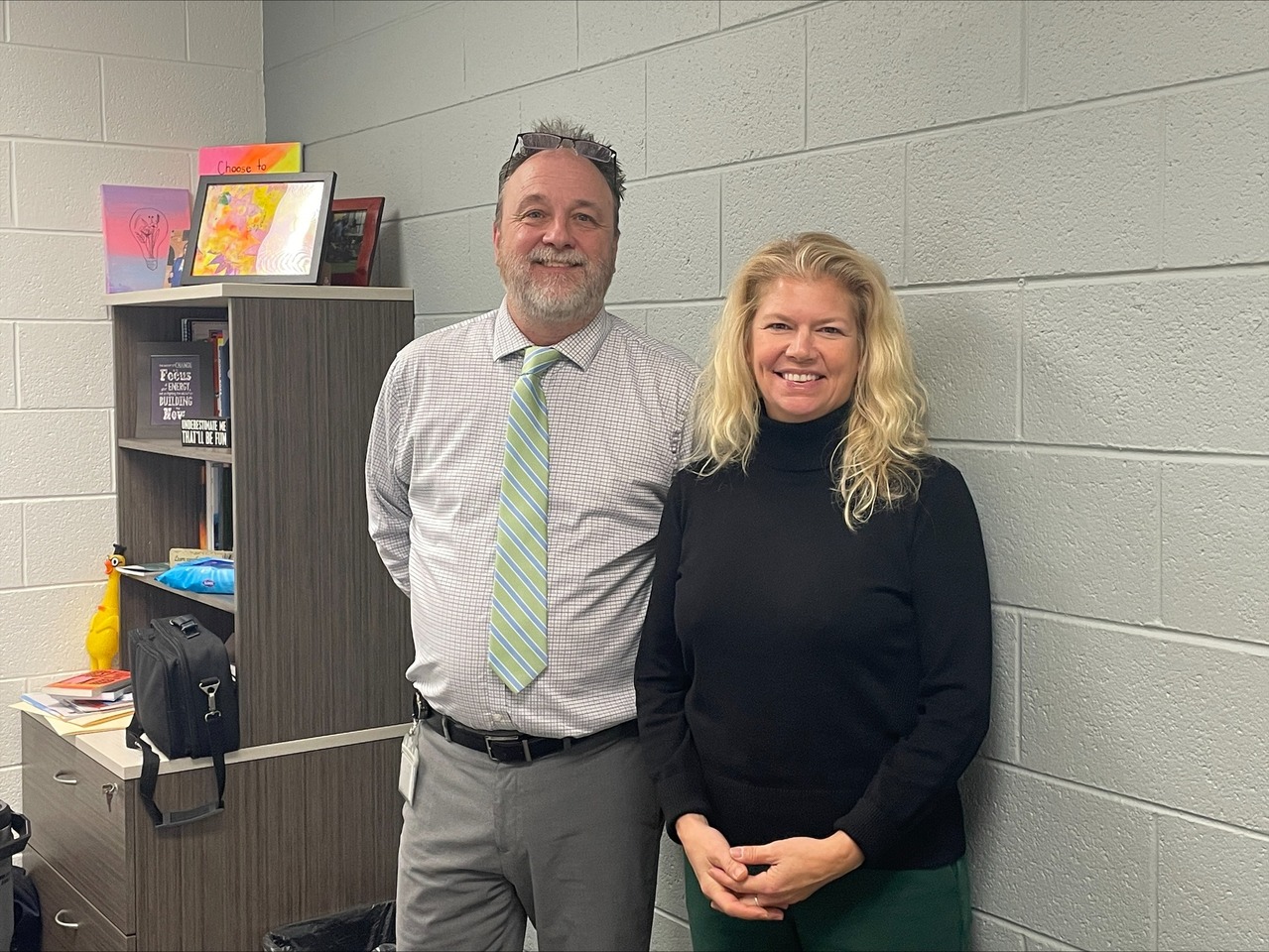 Denys Macaluso, Vice President at MSU Federal Credit Union, stands next to Michel McDonald inside a school office, reflecting on the insights gained during Ingham ISD’s